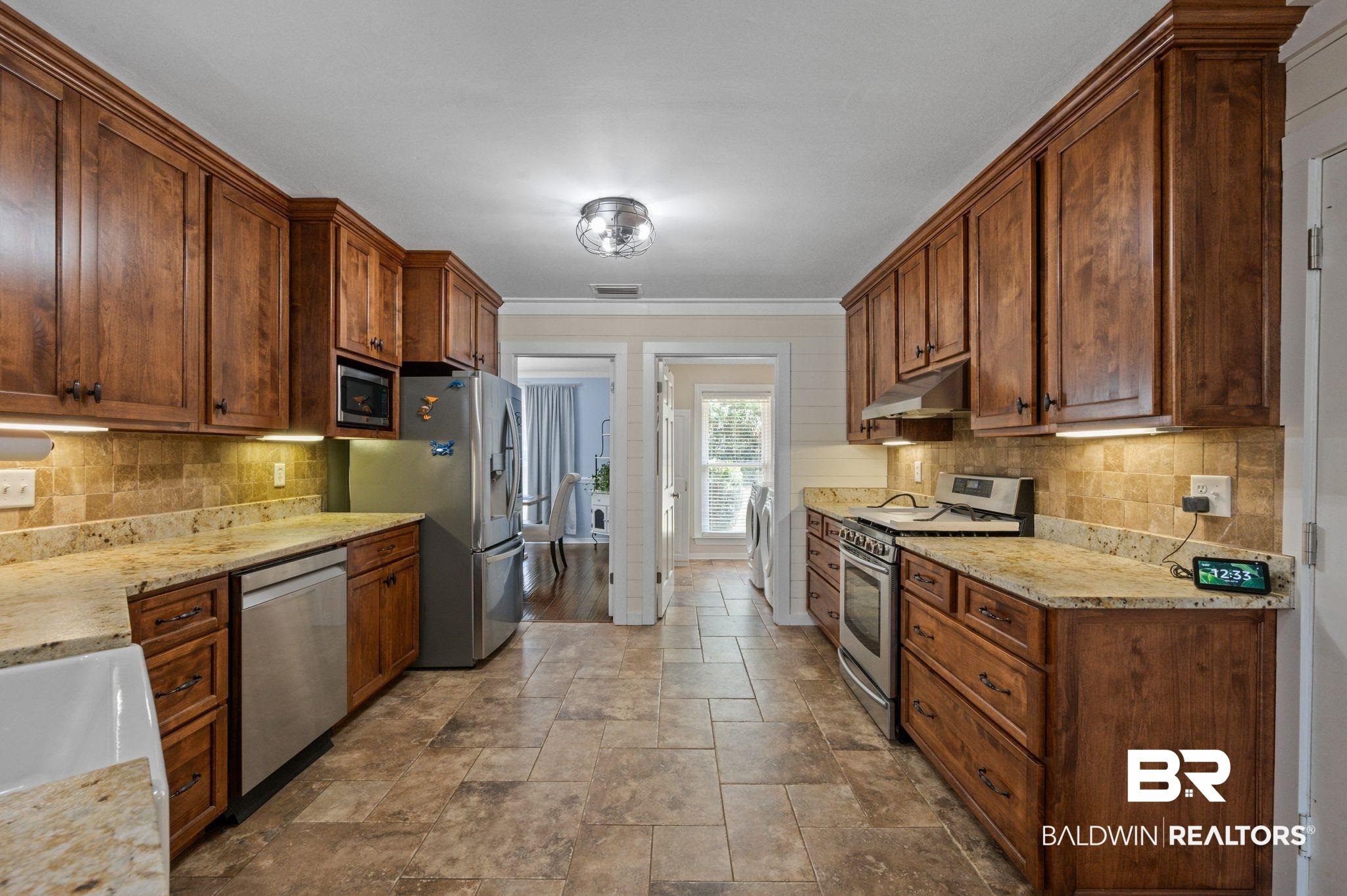 20037 County Road 33 Fairhope, AL 36532 - Photo 14 of 79 Kitchen with washer / clothes dryer, ornamental molding, appliances with stainless steel finishes, light stone counters, and tasteful backsplash