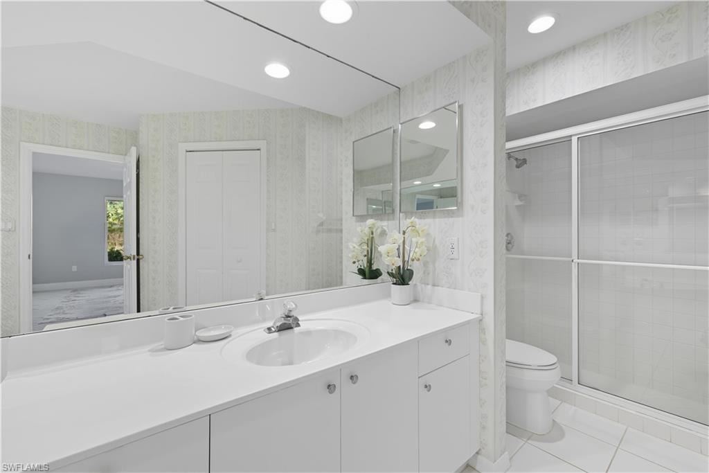 3605 Corinthian Way Naples, FL 34105 - Photo 20 of 33 a bathroom with a double vanity sink toilet and shower
