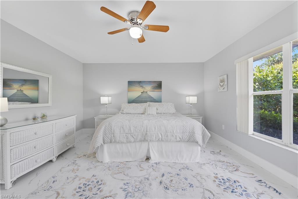 3605 Corinthian Way Naples, FL 34105 - Photo 8 of 33 a bedroom with a large bed and a window