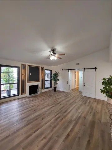 a view of empty room with wooden floor fireplace and windows