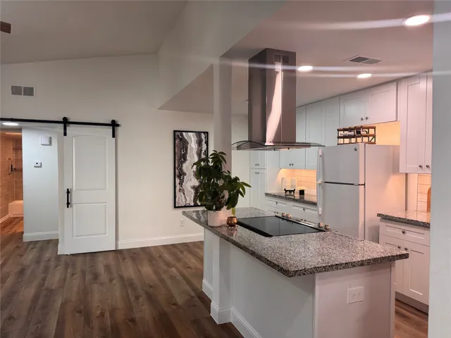 a kitchen with stainless steel appliances granite countertop a sink and a refrigerator