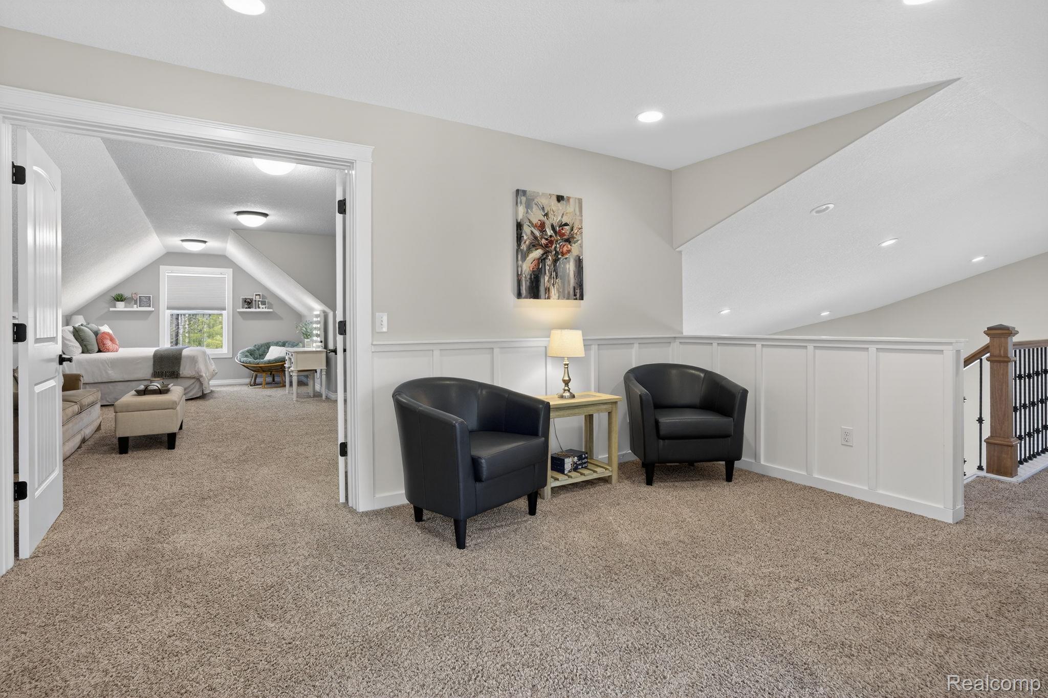 101 Highview Road Traverse City, MI 49696 - Photo 47 of 88 Living area with carpet flooring, vaulted ceiling, a decorative wall, recessed lighting, and wainscoting