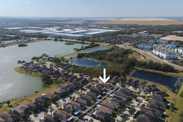 an aerial view of ocean and residential houses with outdoor space