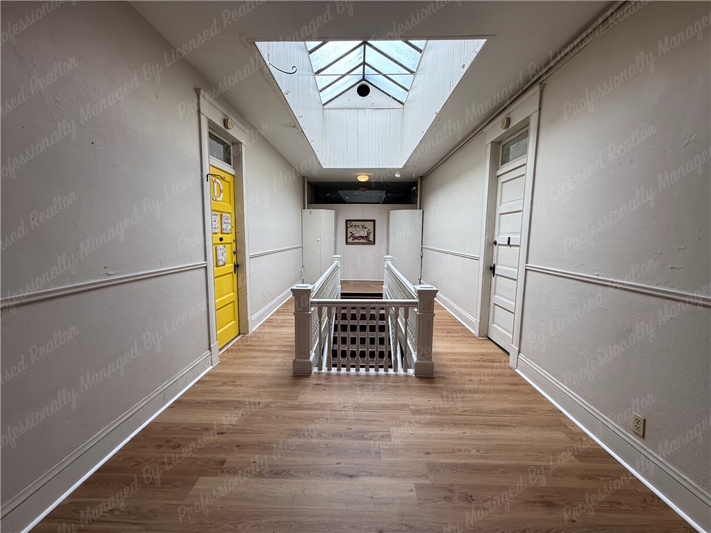 44 West High Street, Unit D Springfield, OH 45502 - Photo 3 of 25 This spacious hallway features rich hardwood flooring and a beautiful skylight, brightening the entire area.