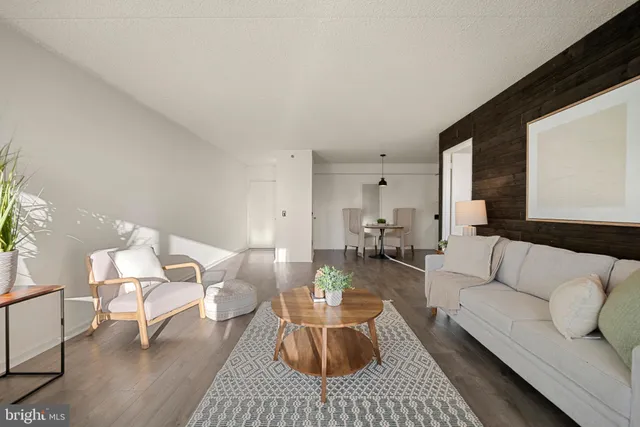 a living room with furniture a rug and a table