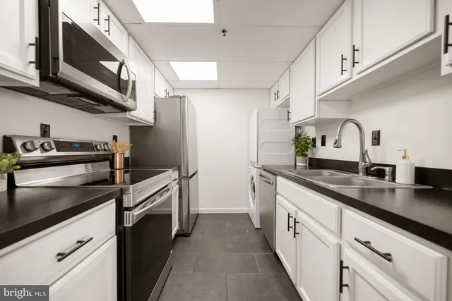 a kitchen with stainless steel appliances granite countertop a sink a stove and a microwave