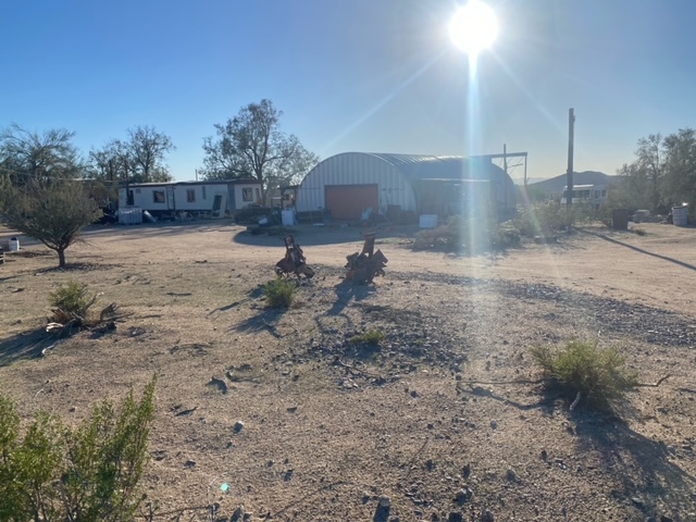 14355 Anegam Road Yucca, AZ 86438 - Photo 16 of 16 View of yard featuring an outbuilding, an outdoor structure, a garage, and driveway