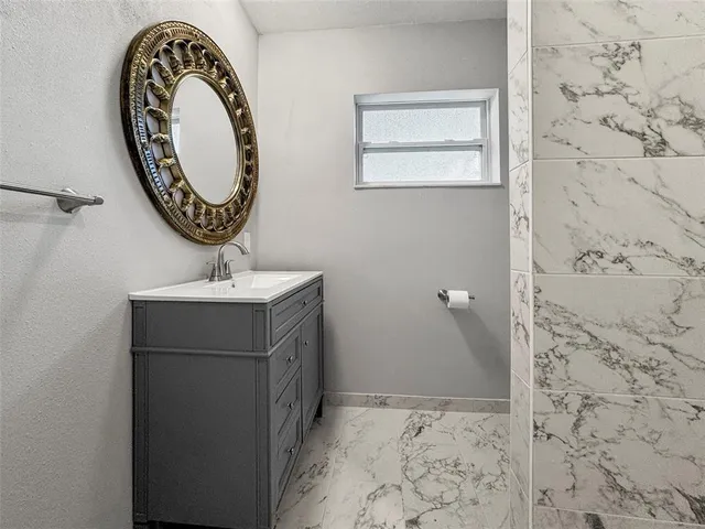 a view of a room with a chandelier fan and wooden floor