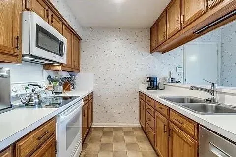 a kitchen with stainless steel appliances granite countertop a sink stove and microwave