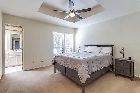 a spacious bedroom with a bed and a chandelier