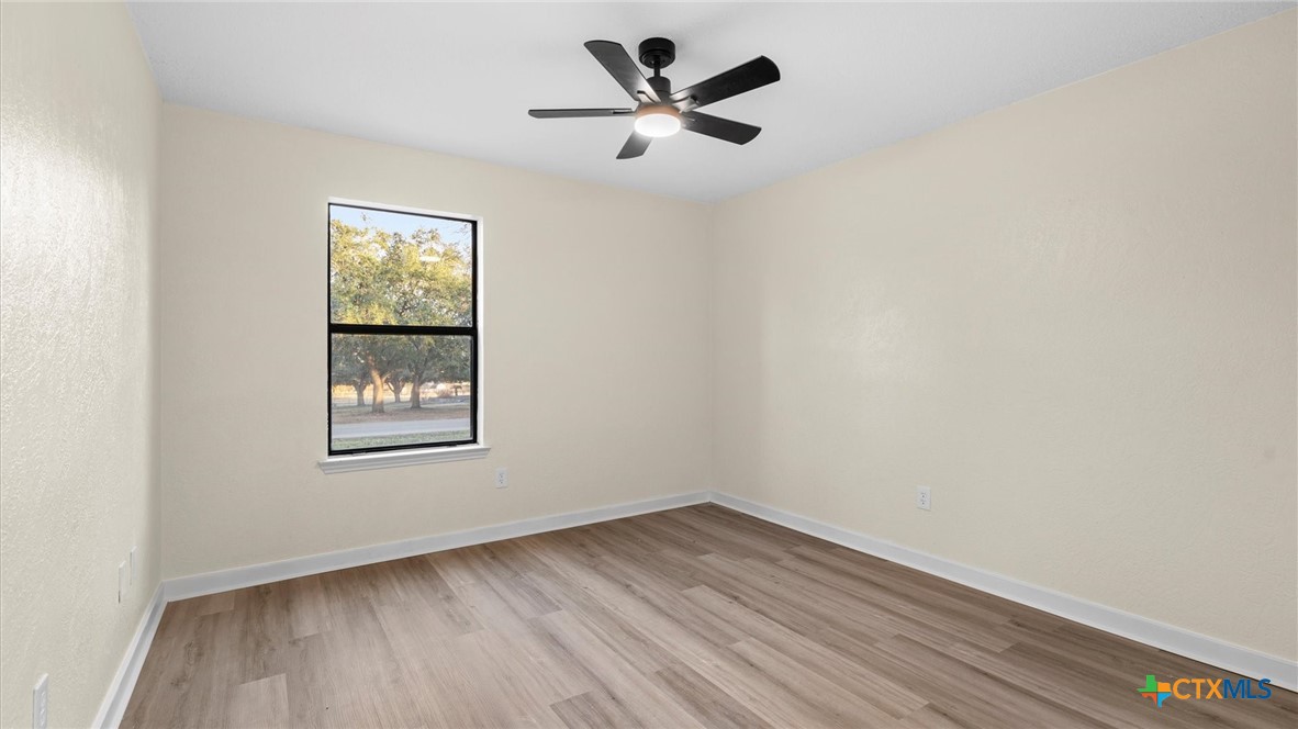 300 Ridge Crest Drive Seguin, TX 78155 - Photo 13 of 33 an empty room with wooden floor and windows