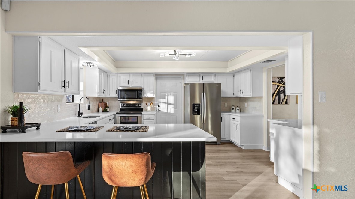 300 Ridge Crest Drive Seguin, TX 78155 - Photo 7 of 33 a kitchen with stainless steel appliances a refrigerator and a stove top oven