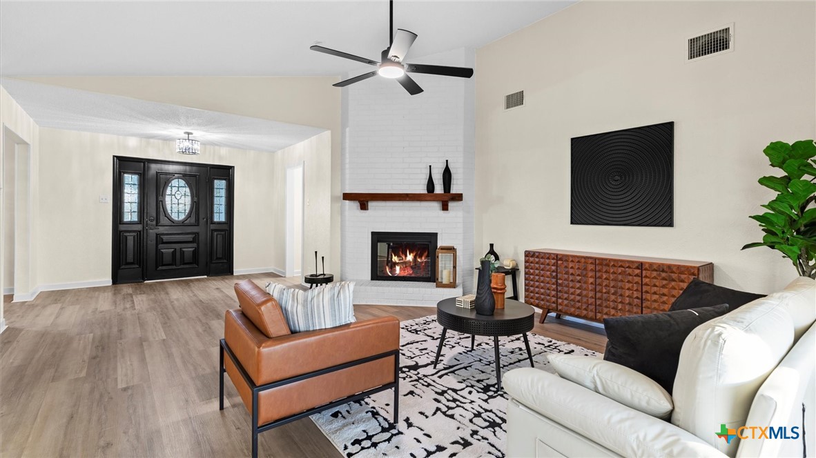 300 Ridge Crest Drive Seguin, TX 78155 - Photo 8 of 33 a living room with furniture a flat screen tv and a fireplace