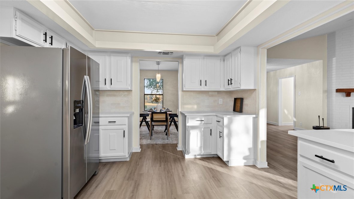 300 Ridge Crest Drive Seguin, TX 78155 - Photo 9 of 33 a kitchen with white cabinets and stainless steel appliances