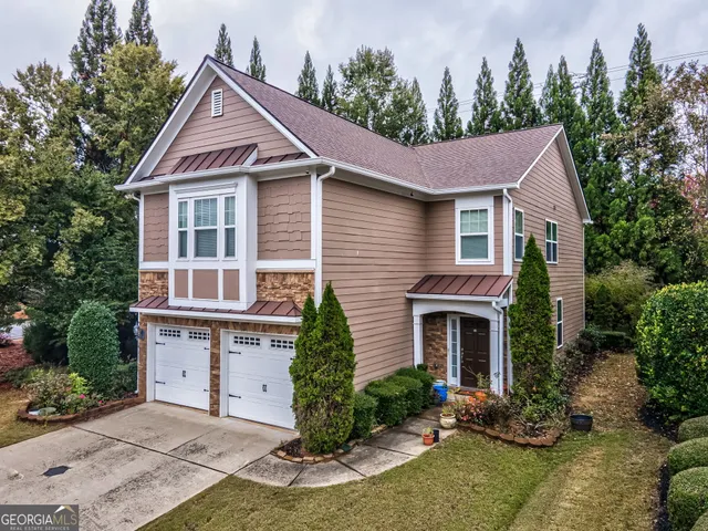 a front view of a house with a yard and trees