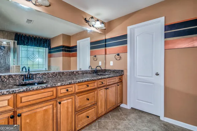 a bathroom with a granite countertop sink and a mirror