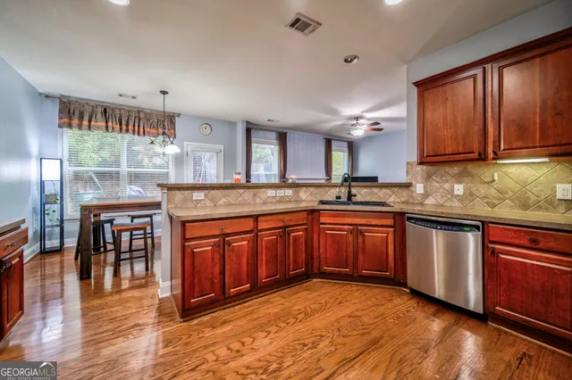 a kitchen with stainless steel appliances granite countertop wooden cabinets a stove a sink and dishwasher