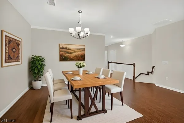 a view of a dining room with furniture wooden floor and chandelier