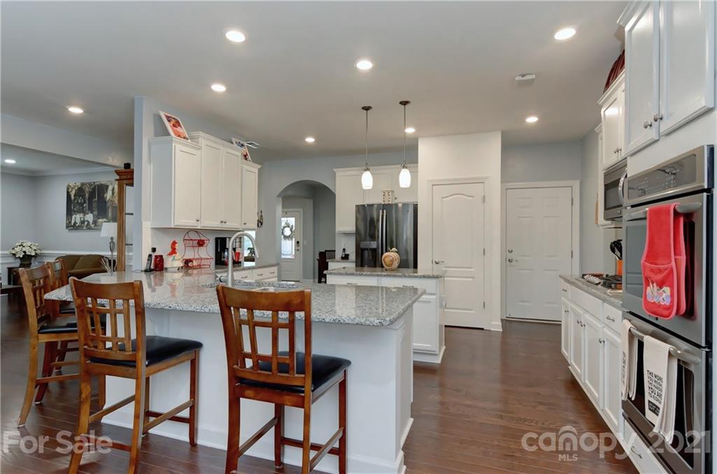 4978 Samoa Ridge Drive Lancaster, SC 29720 - Photo 12 of 38 a large kitchen with stainless steel appliances kitchen island granite countertop a table chairs and a stove