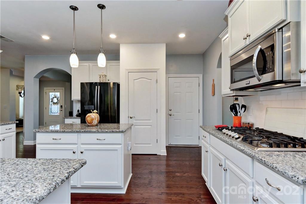 4978 Samoa Ridge Drive Lancaster, SC 29720 - Photo 14 of 38 a kitchen with stainless steel appliances kitchen island granite countertop a stove a sink and a microwave