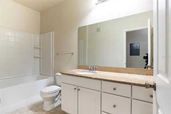 a bathroom with a granite countertop sink a toilet and shower