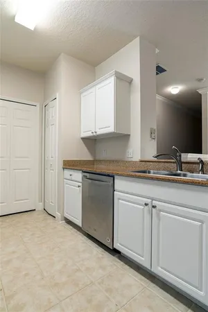 a kitchen with granite countertop white cabinets and white appliances