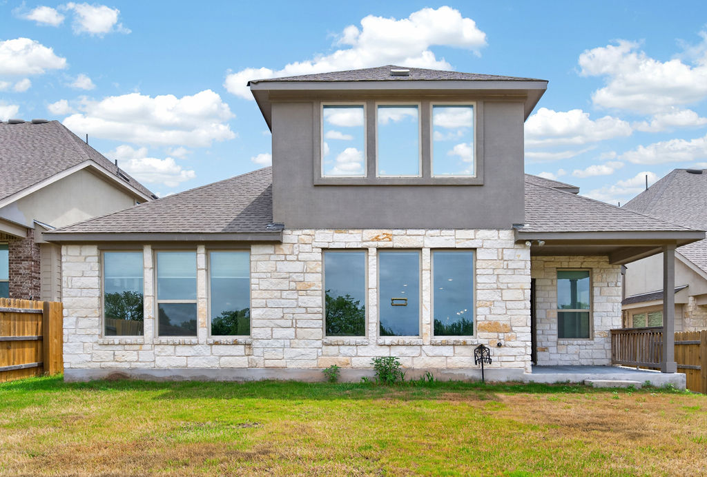 1332 Ridge Runner Drive Georgetown, TX 78628 - Photo 35 of 40 A striking modern residence boasts a multi-textured exterior and an inviting covered patio, all set against a backdrop of natural landscaping.