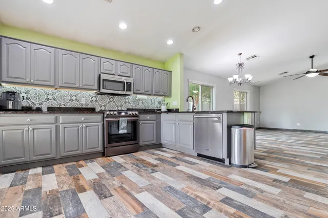 a kitchen with stainless steel appliances granite countertop a stove sink and cabinets