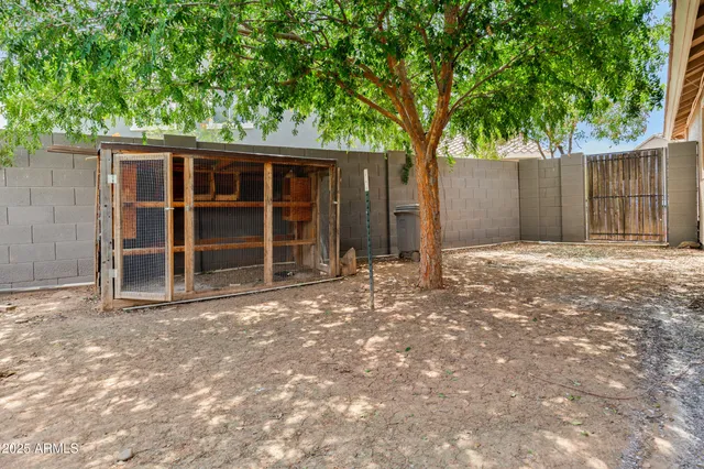 a view of backyard with large trees and wooden fence
