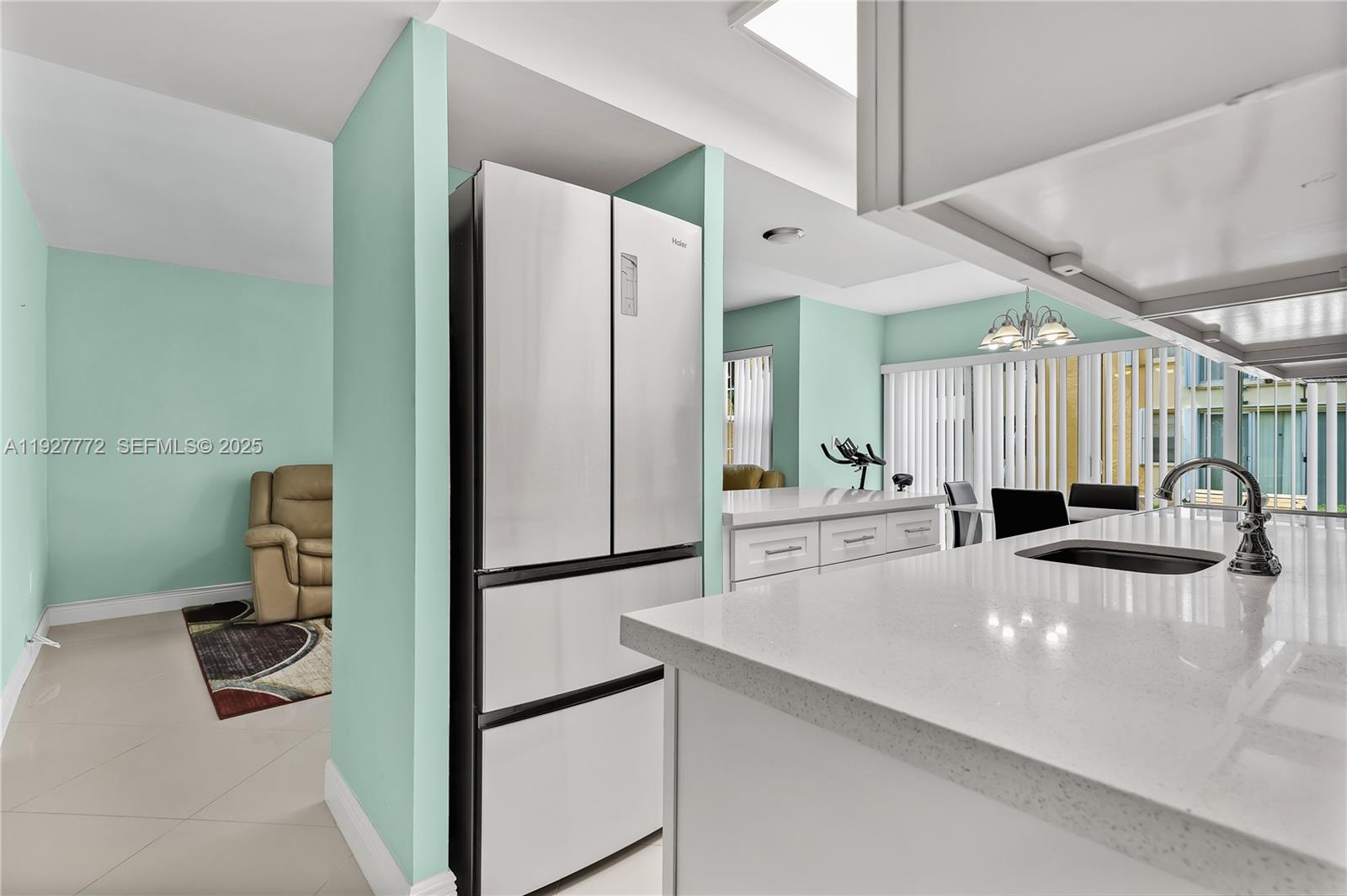 9311 Southwest 4th Street, Unit 105B Miami, FL 33174 - Photo 11 of 19 a kitchen with a refrigerator a sink and a cabinets