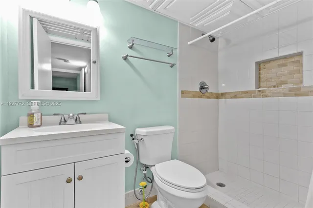 a bathroom with a toilet sink vanity and mirror