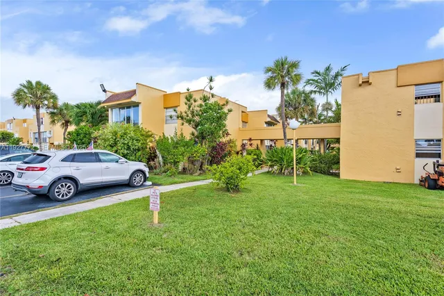 a car parked in front of a house with a big yard