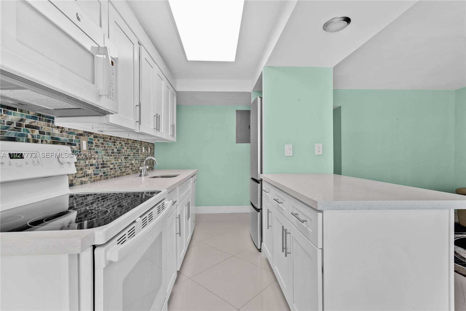 9311 Southwest 4th Street, Unit 105B Miami, FL 33174 - Photo 8 of 19 a kitchen with white cabinets and white appliances