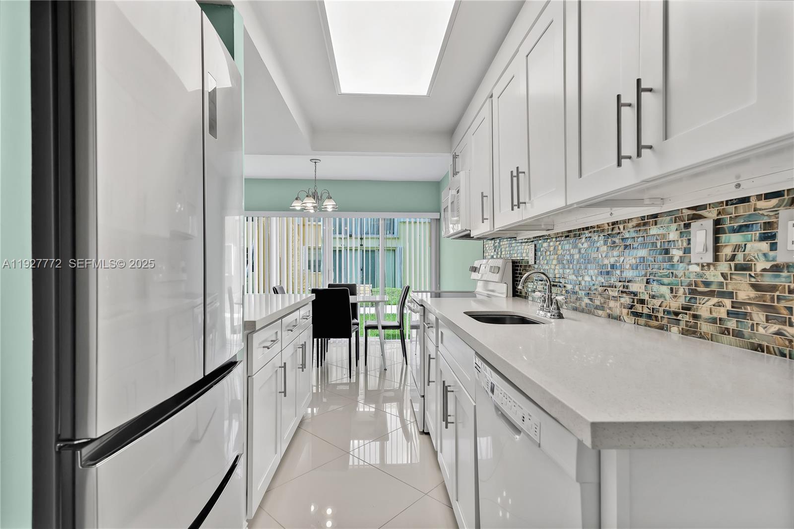 9311 Southwest 4th Street, Unit 105B Miami, FL 33174 - Photo 10 of 19 a kitchen with a sink a stove and chairs