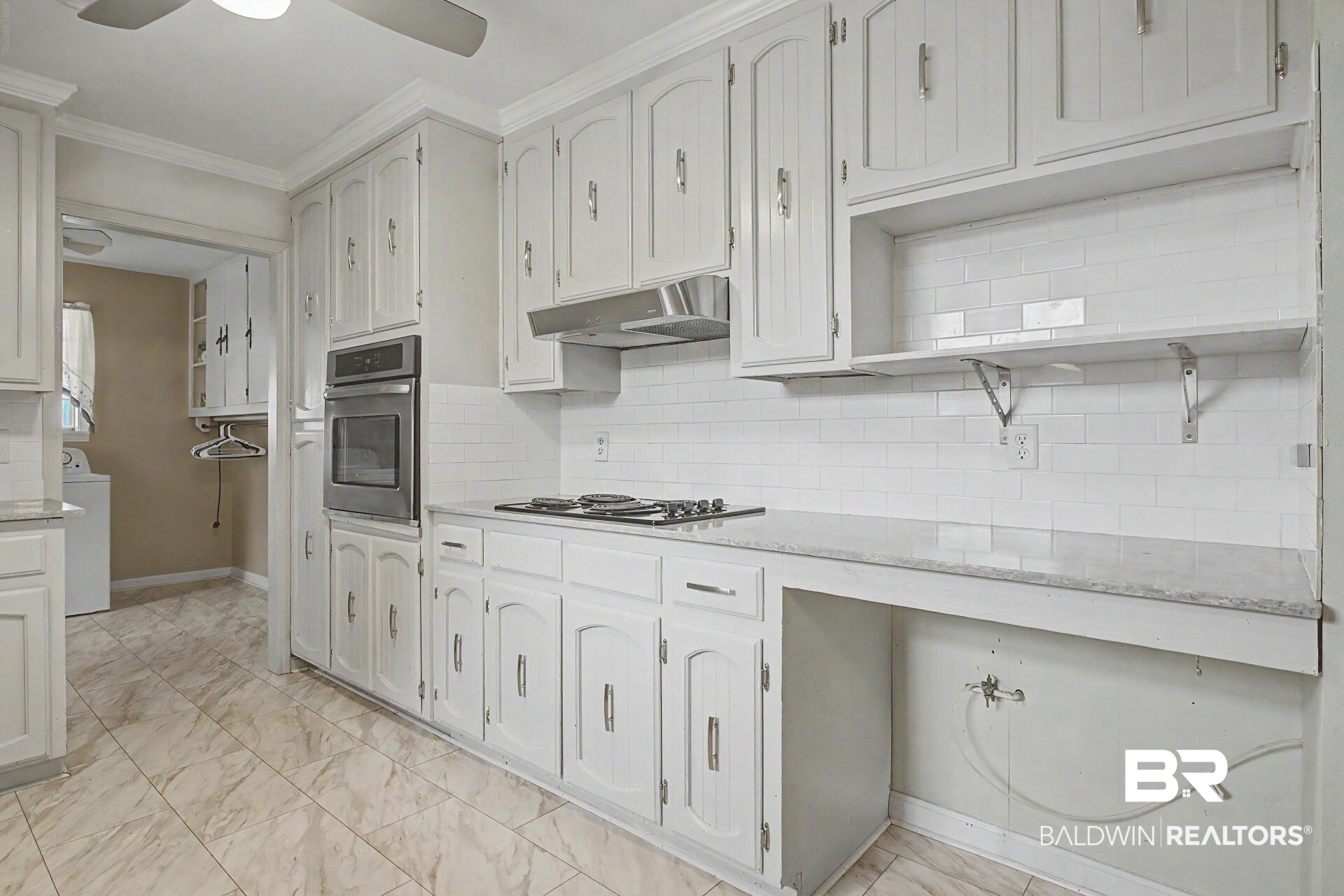 3791 Robinsonville Road Atmore, AL 36502 - Photo 26 of 47 Kitchen featuring ample white cabinetry, tile flooring, a gas range with a stainless steel range hood, a built-in oven, and white subway tile backsplash