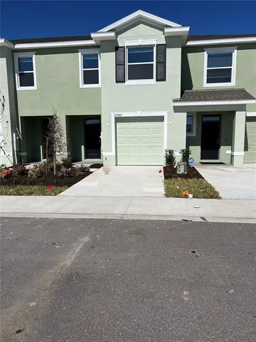 a front view of a house with yard and parking