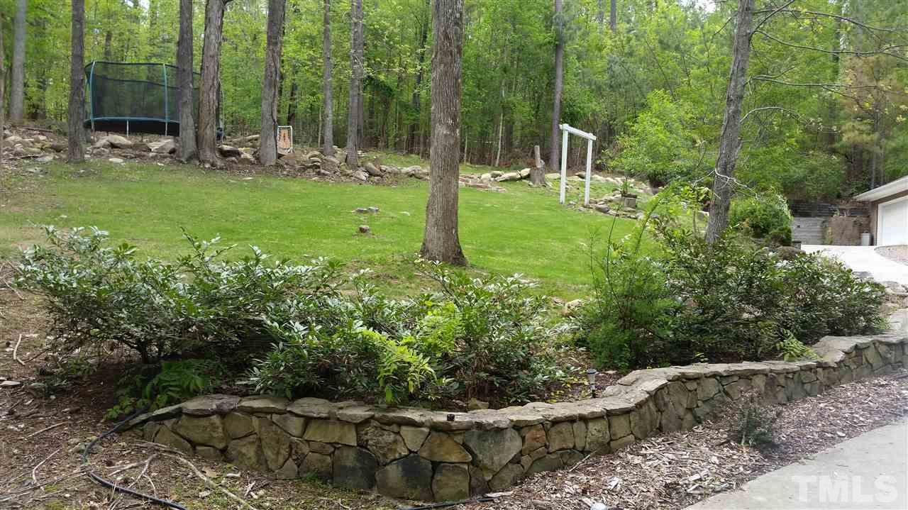 505 Booth Road Chapel Hill, NC 27516 - Photo 23 of 25 a view of a backyard with potted plants and large trees
