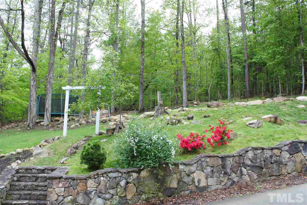 505 Booth Road Chapel Hill, NC 27516 - Photo 24 of 25 a small yard with lots of green space and trees in the background