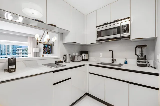 a kitchen with stainless steel appliances granite countertop a sink and a microwave