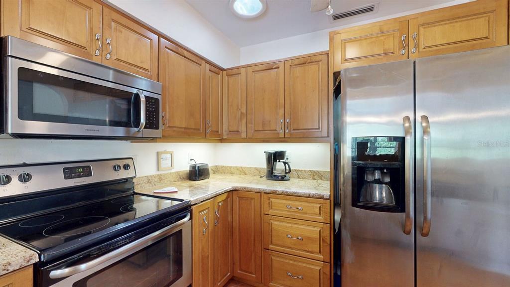 1618 Tuscola Road Clearwater, FL 33756 - Photo 21 of 64 a kitchen with stainless steel appliances granite countertop a refrigerator and a stove top oven