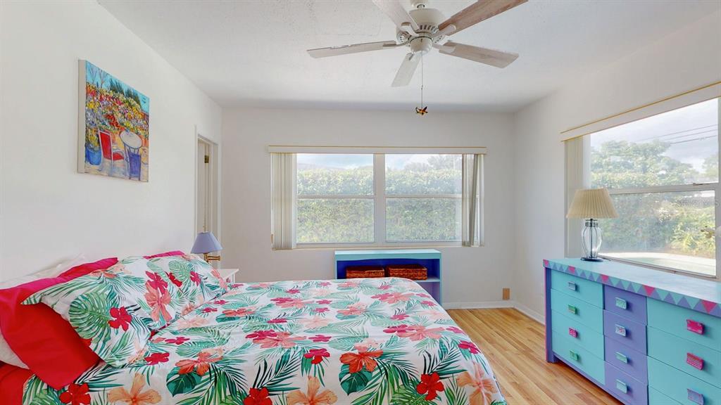1618 Tuscola Road Clearwater, FL 33756 - Photo 27 of 64 a bedroom with a bed a window and a chandelier