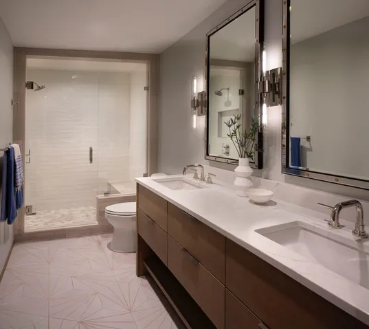a bathroom with a double vanity sink toilet and shower