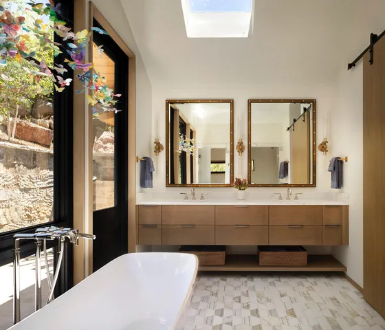 a bathroom with a double vanity sink a mirror and a bathtub