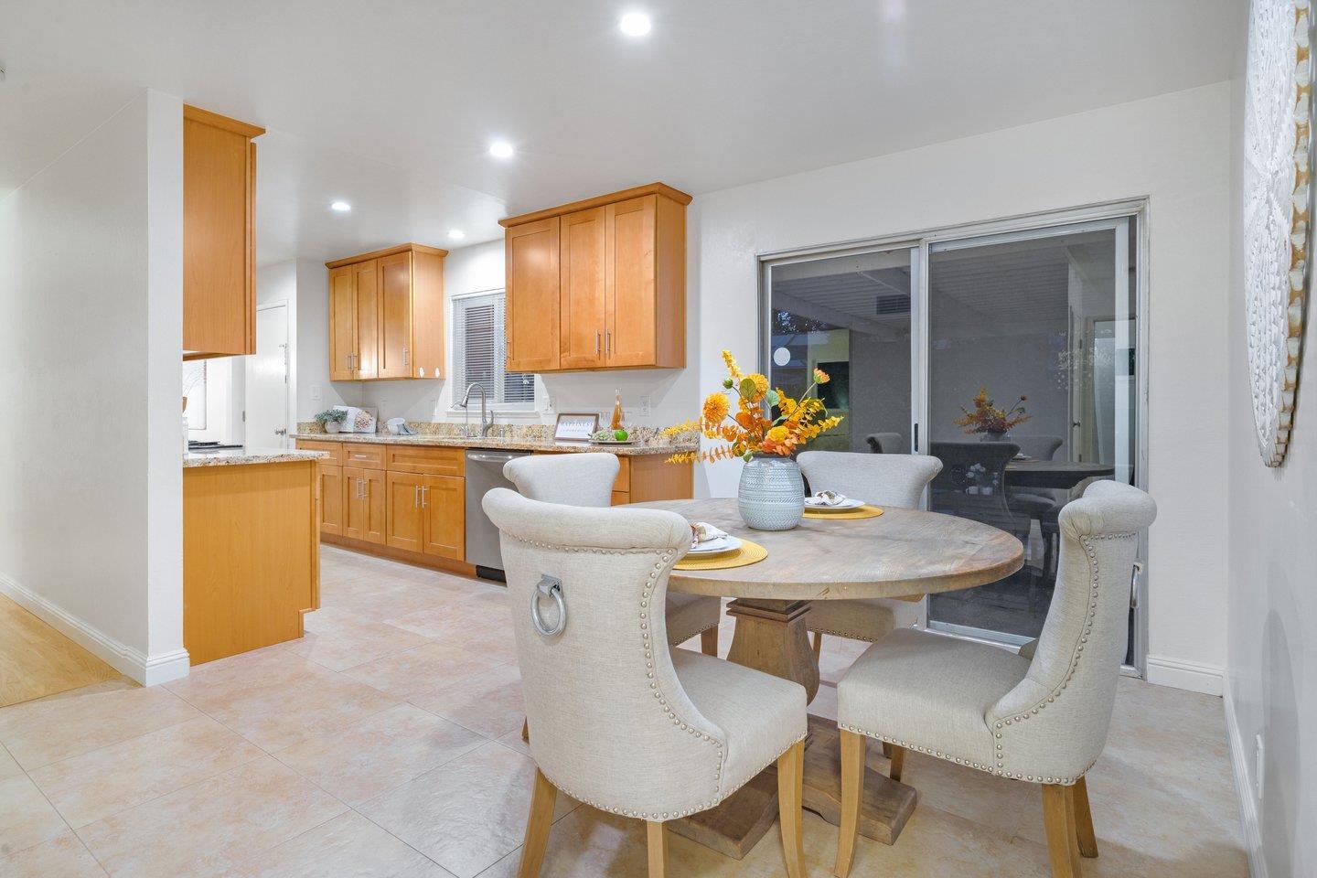 7457 Rollingdell Drive Cupertino, CA 95014 - Photo 16 of 33 a dining room with stainless steel appliances kitchen island granite countertop a sink a stove a dining table and chairs