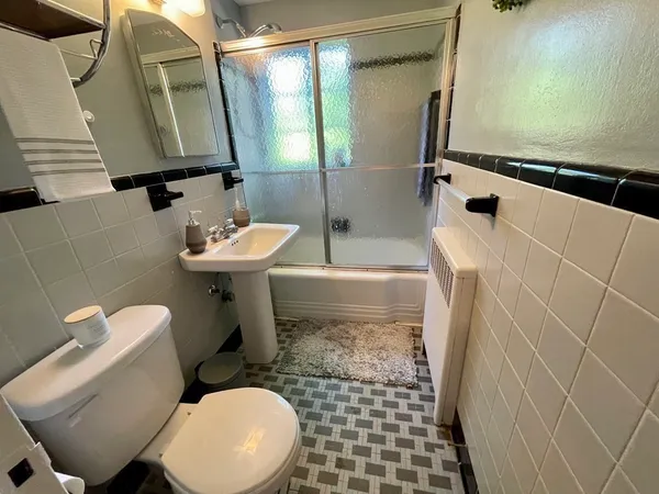 a bathroom with a sink a toilet and mirror