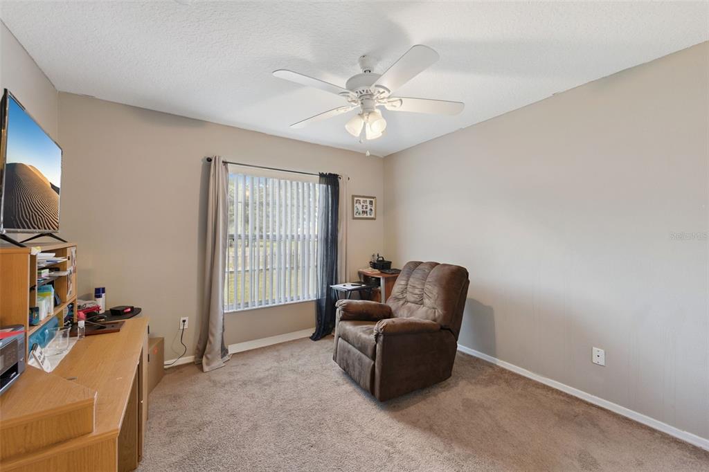 1308 Bates Avenue Eustis, FL 32726 - Photo 12 of 16 a living room with furniture a chandelier and a window