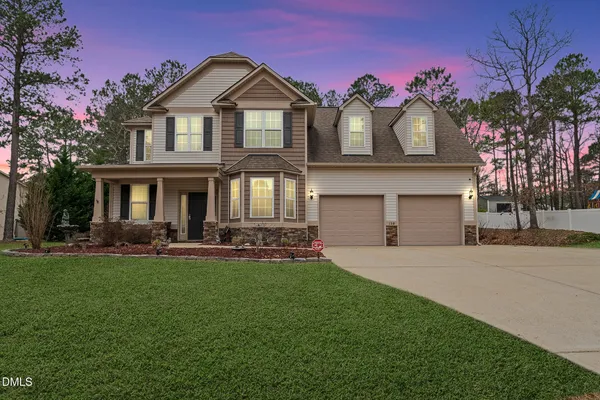a front view of a house with a garden and yard