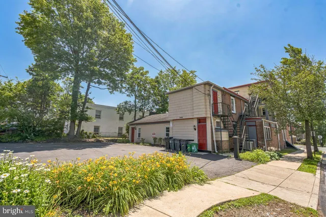 a front view of a house with a yard and potted plants