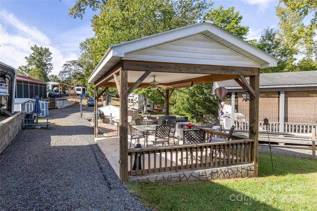 a view of a patio with table and chairs with wooden floor and fence