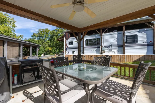 a view of a patio with table and chairs under an umbrella